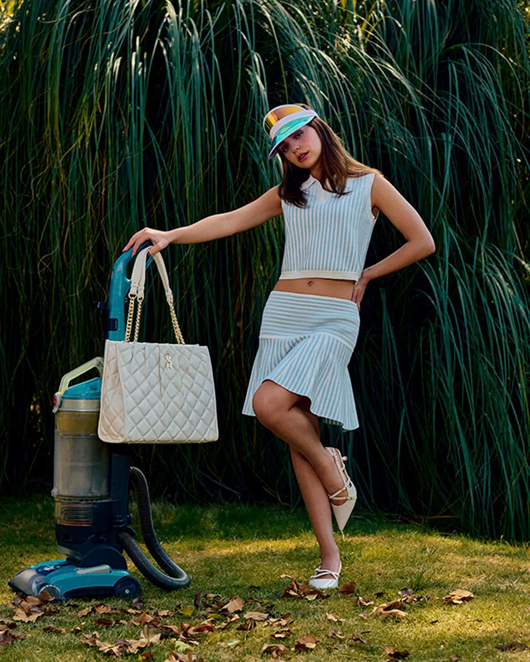Look urbano: Mujer con bolso tote blanco acolchado, blusa de rayas y falda de rayas blanco con azul, zapatos puntiagudos con tacón Steve Madden, estilo chic moderno para mujer.